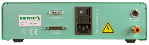 The image shows the back of a green device with several ports: a power switch, jacks for foot pedals and a VG port, as well as outlets for air with pressure readings (0.1 and 0.7 bar).