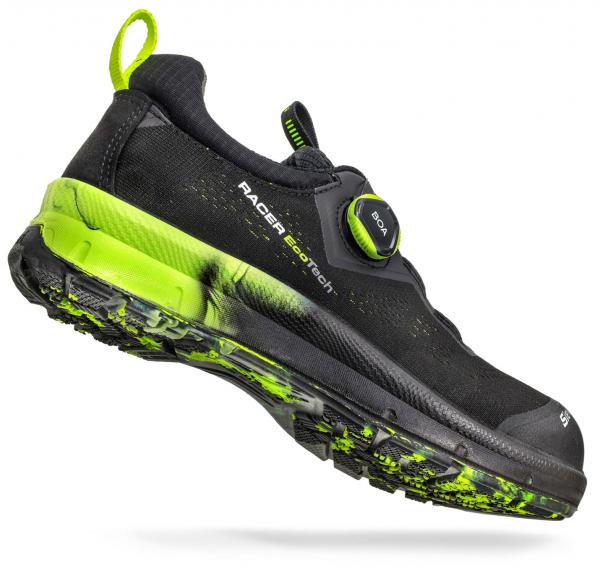 The shoe is sleek and sporty, in black with bright green accents. The sole has a textured structure for better grip. A twist closure allows for easy adjustment.