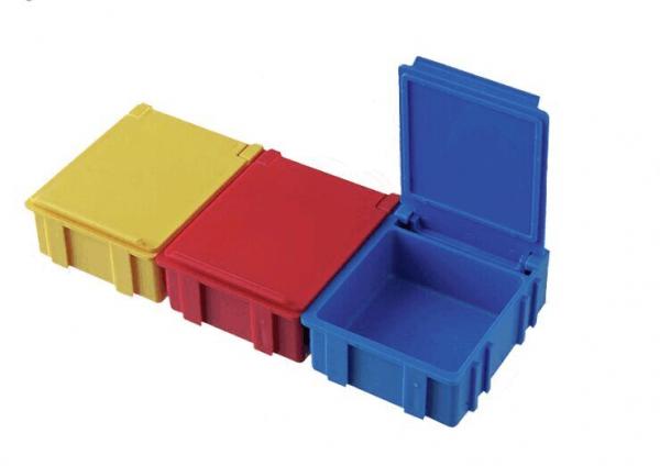 The image shows three rectangular plastic boxes in yellow, red, and blue. The yellow and red boxes are closed, the blue box is open. They are arranged in a row.