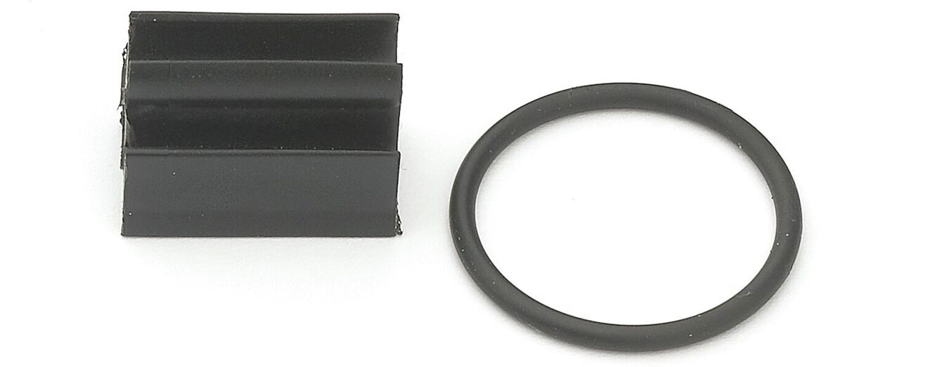 The image shows two black objects: A square part with several vertical grooves on the left, and a round O-ring on the right. Both are dark and made of rubber or a similar material.