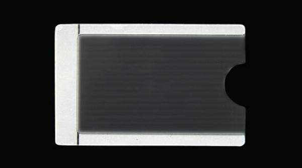 The image shows a rectangular, flat object in black and white. The left side has a continuous white area, while the right side has a recess. The background is black.