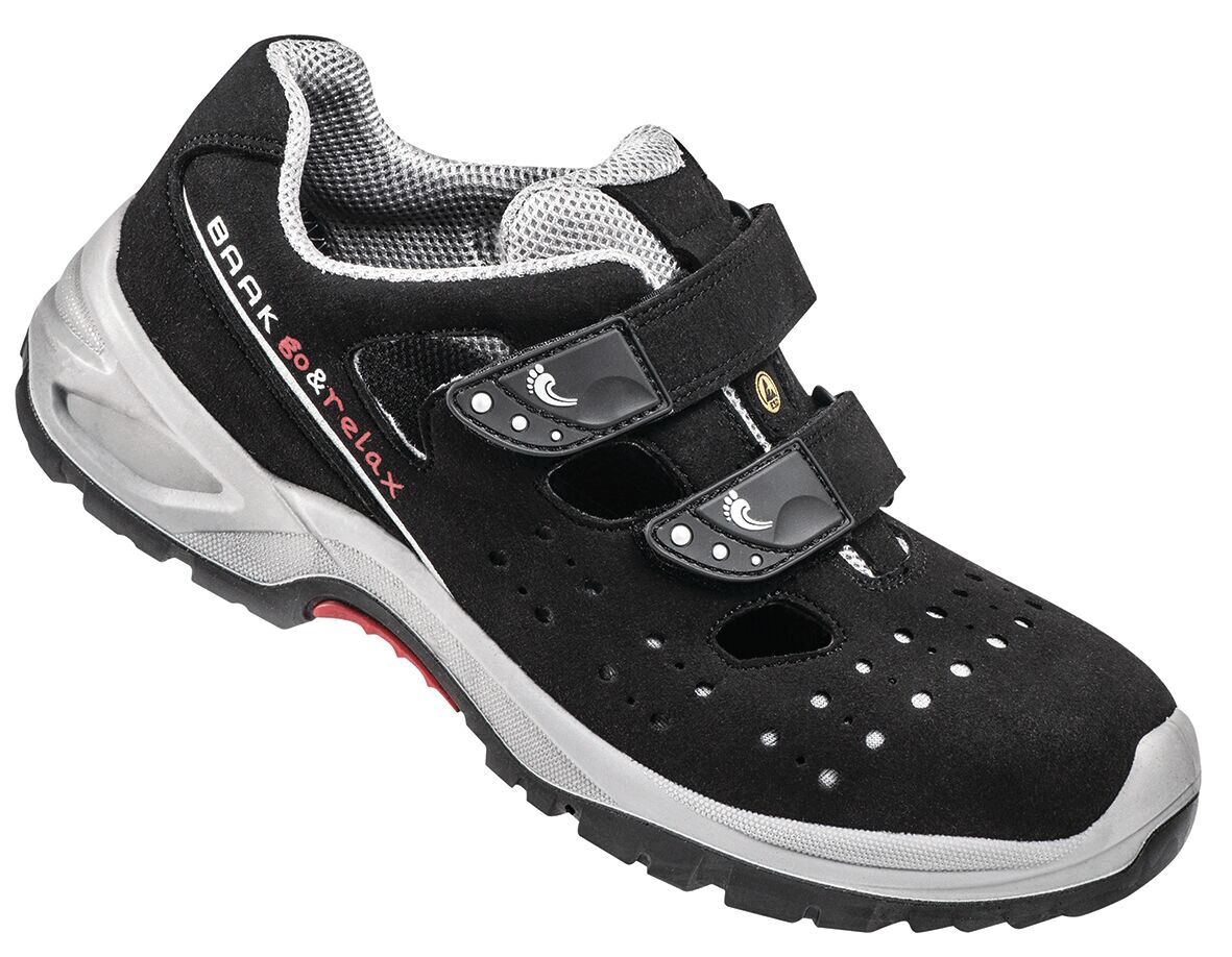 The image shows a black shoe with two wide Velcro straps. The shoe has side ventilation holes and a grippy, beige-colored sole. It appears sporty and comfortable.